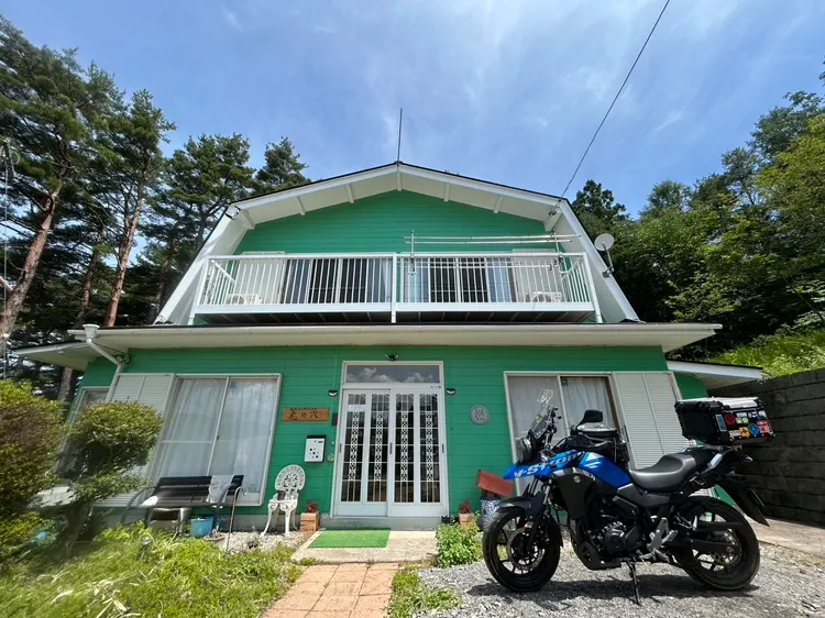 緑の外壁が印象的な佐久ライダーハウス虎の穴とバイク